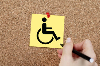 Disabled sign pinned on cork noticeboard