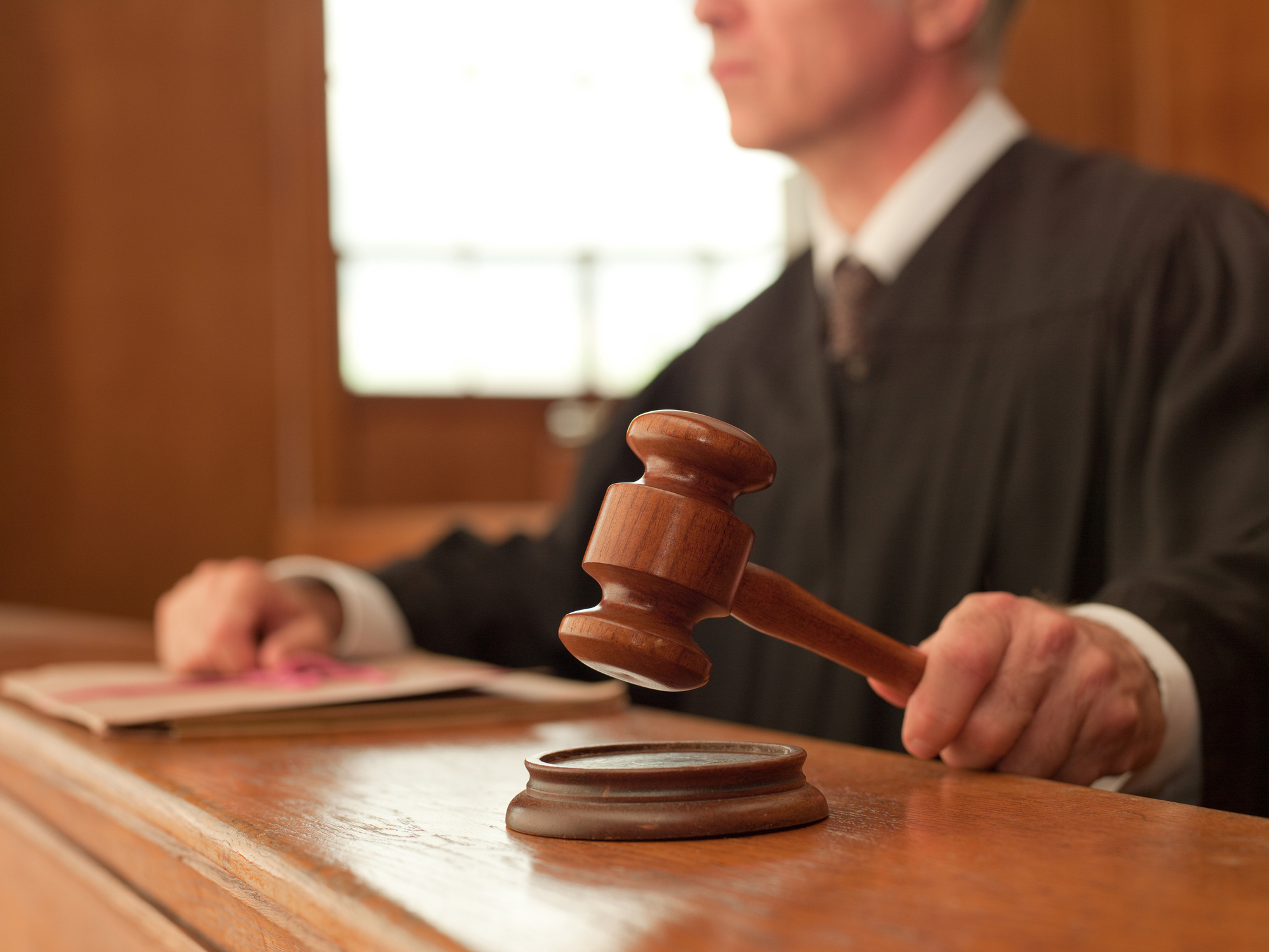 Judge holding gavel in courtroom